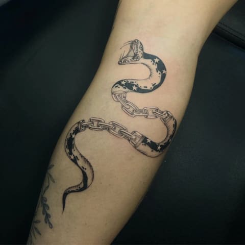Fine-line snake tattoo by a SKYN artist
